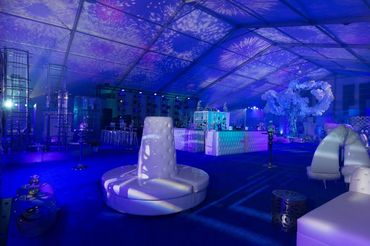 Brilliant lighting and projections at a tented event with a beautifully designed setting.