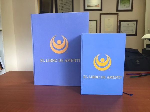 Two blue books titled "EL LIBRO DE AMENTI" on a wooden table.