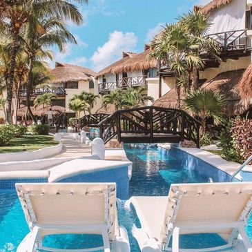 Relaxing pool area with lounge chairs and tropical villas.