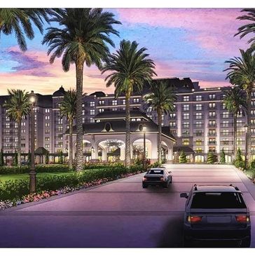 Luxurious hotel entrance at sunset with palm trees.