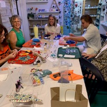 Group of people doing crafts around a table.