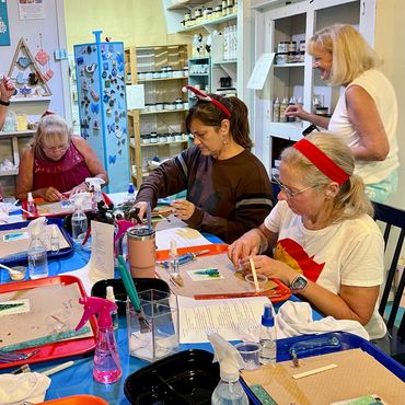 Group of women crafting at a workshop table.