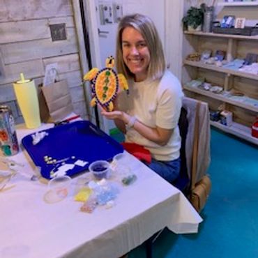 Woman showing a colorful craft turtle.