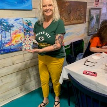 Woman with blonde hair holding a sculpture.