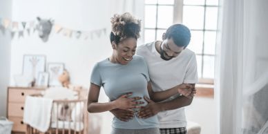 Couple happily embracing with the woman pregnant.