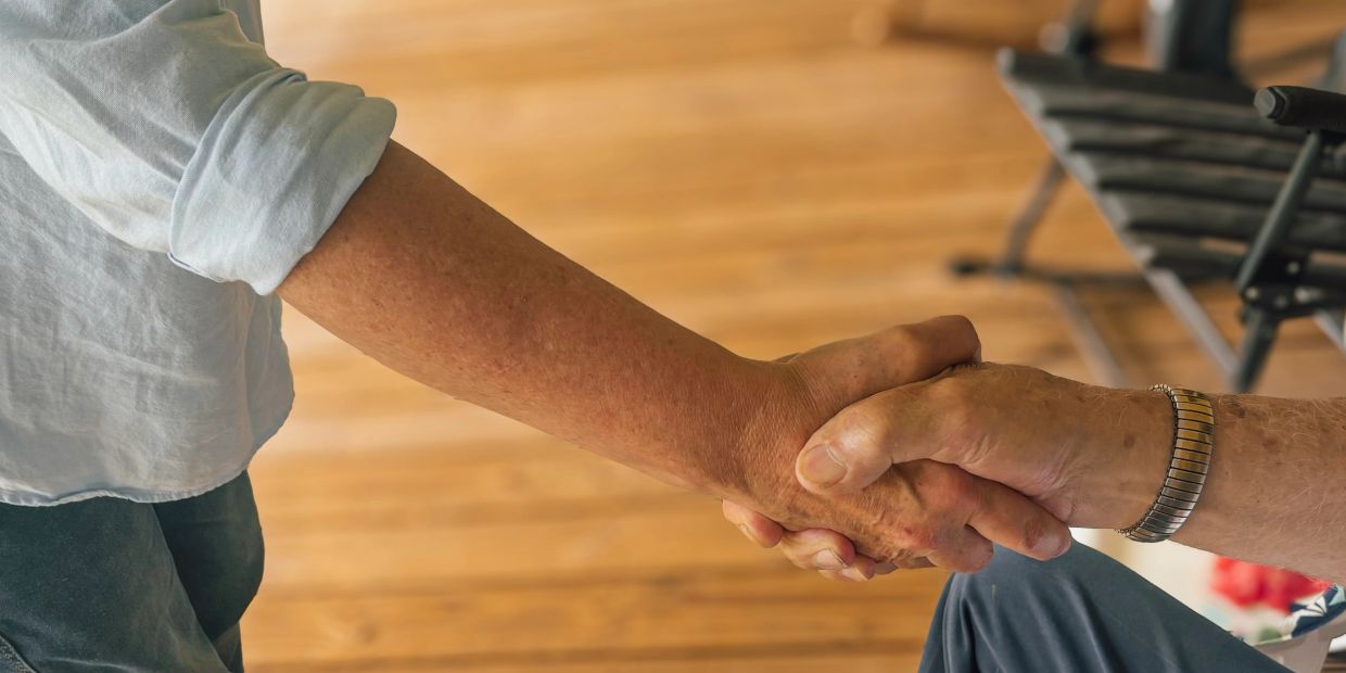 Two people shaking hands closely.