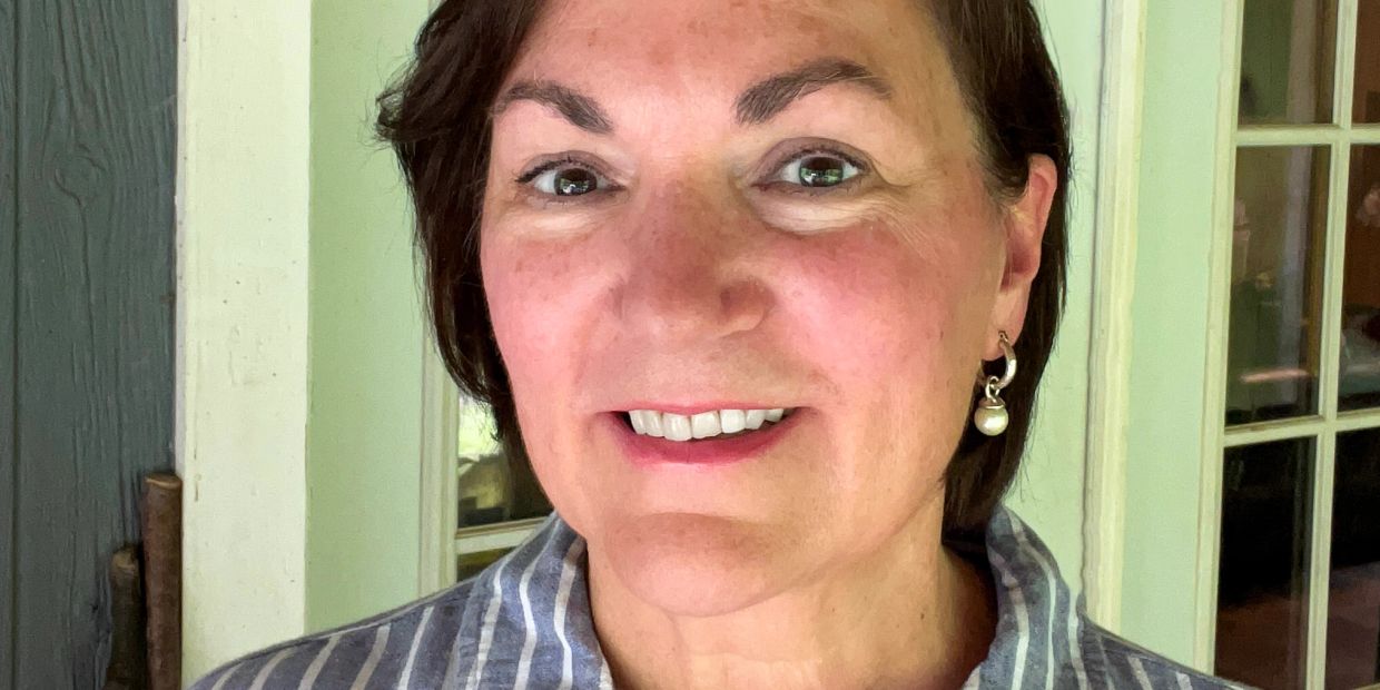 Close-up of a woman smiling indoors.