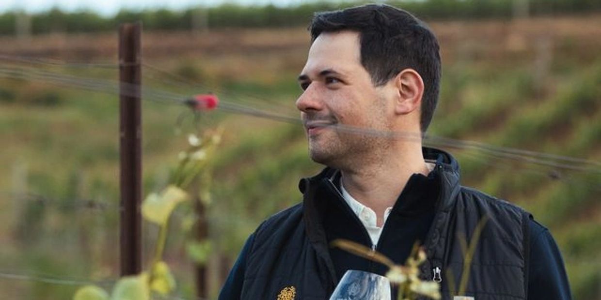 Man enjoying a glass of wine outdoors.