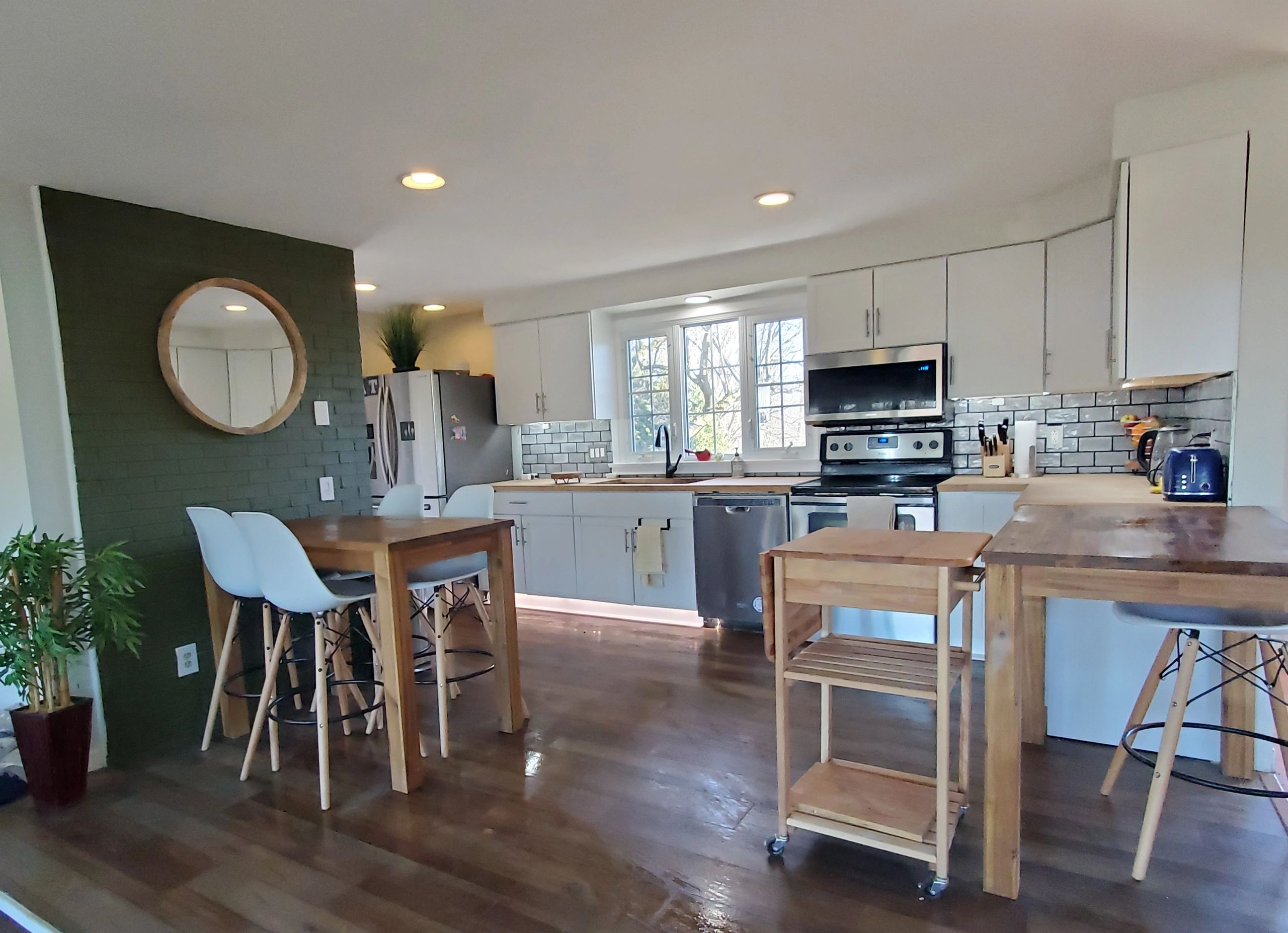 Bright modern kitchen with white cabinets and wooden furniture.