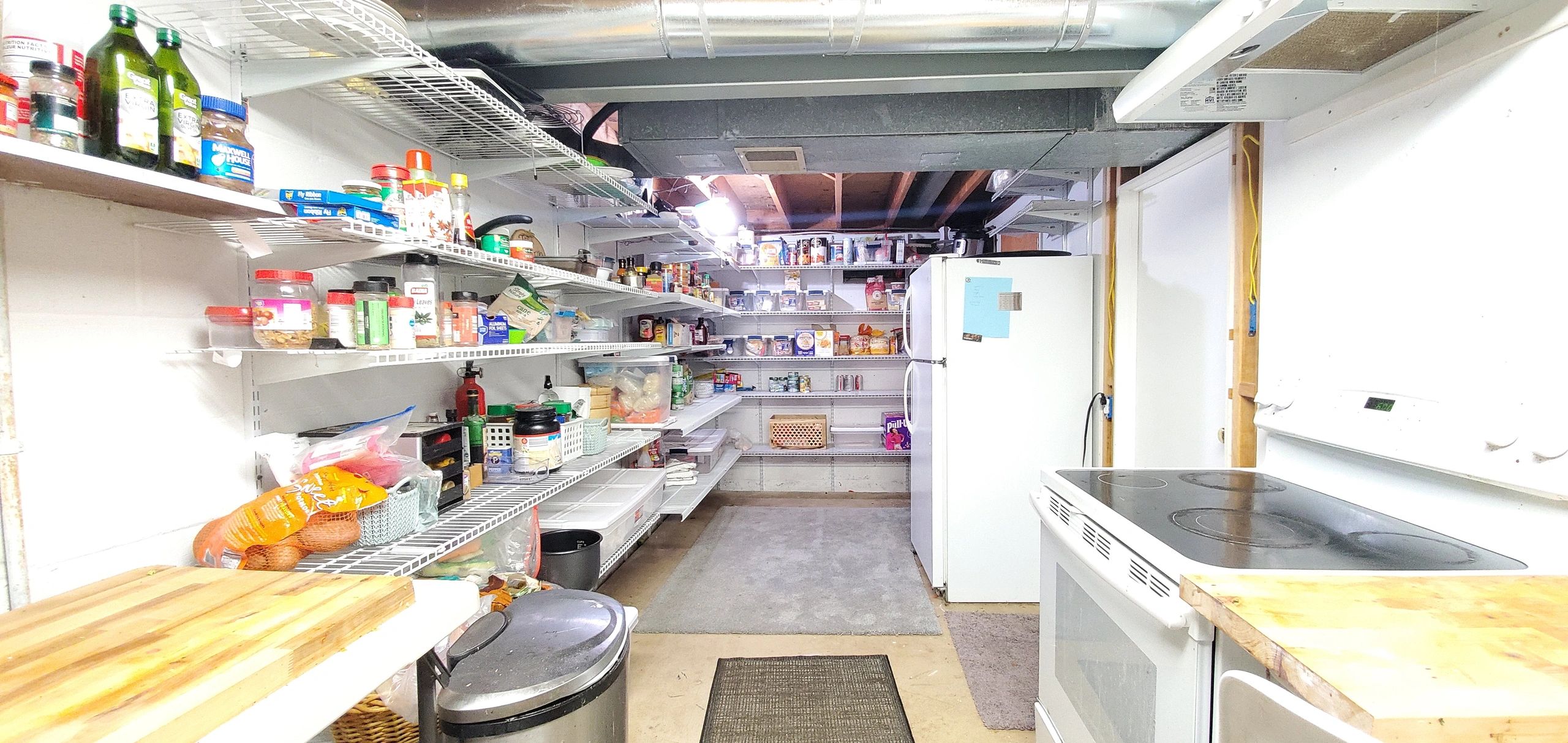 A well-stocked pantry with shelves full of food and kitchen appliances.