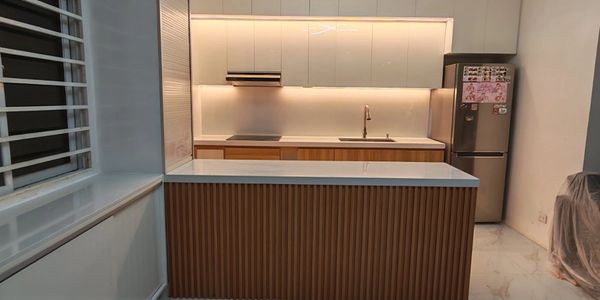 Modern kitchen with white and wood cabinetry and marble floor tiles.