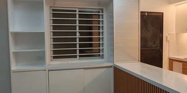 Modern kitchen with white cabinets and marble flooring.