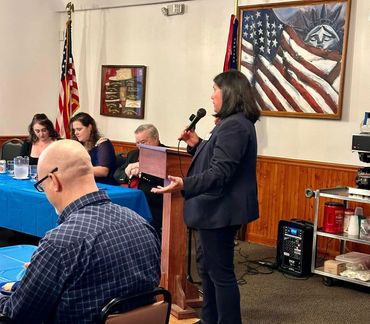 Paula Collins at podium in Lewis County