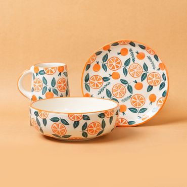 Orange-themed ceramic mug, bowl, and plate set.