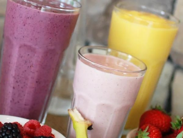 Three colorful fruit smoothies with fresh berries and banana.