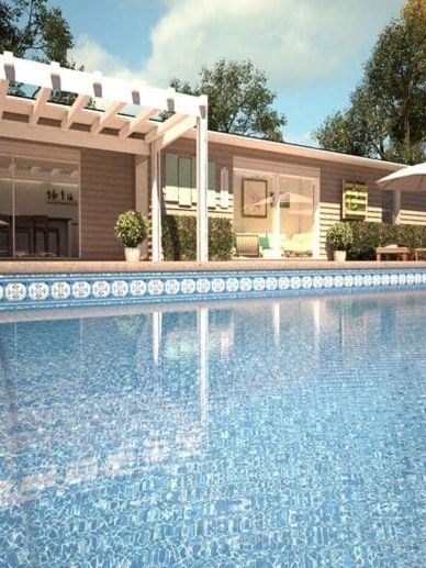 Clear blue swimming pool next to a modern house.