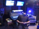 Person sitting in a music studio with equipment and monitors.