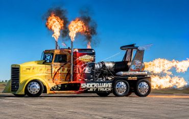 Jet-powered truck shooting flames on a runway.
