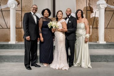 Wedding party posing with bride and groom in formal attire.