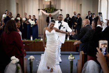 Bride and groom joyfully walk down the aisle after their wedding ceremony.