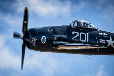 Close-up of a vintage propeller airplane flying in the sky.