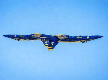 Inverted Blue Angels jets flying in tight formation.
