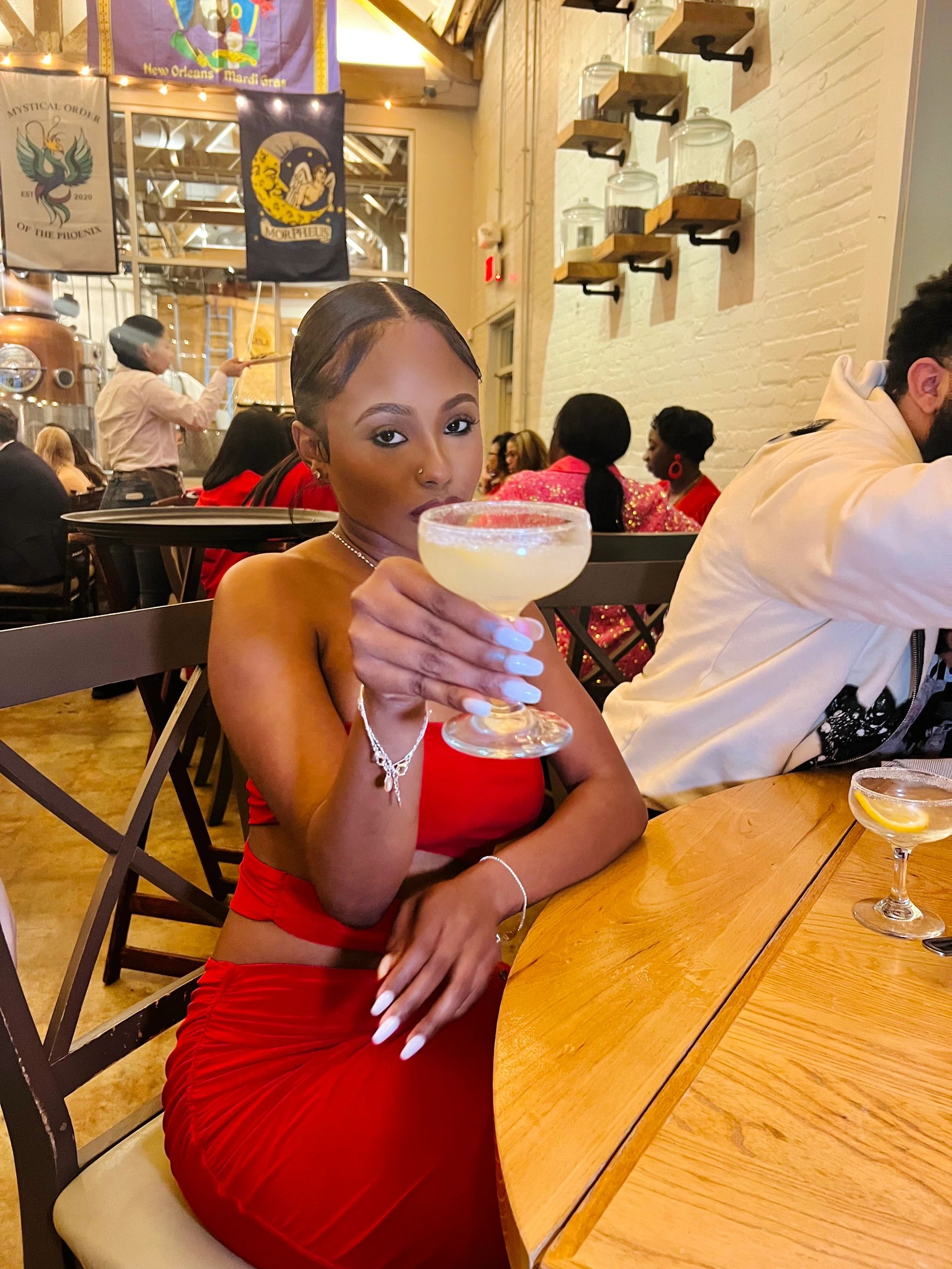 Woman in red dress holding a cocktail glass.