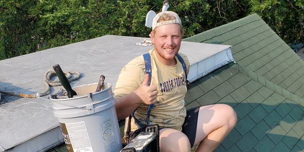Student worker giving thumbs up and roof painting in Fargo, ND