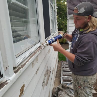 Prairie Rose Project Manager cocking around window sill outside home