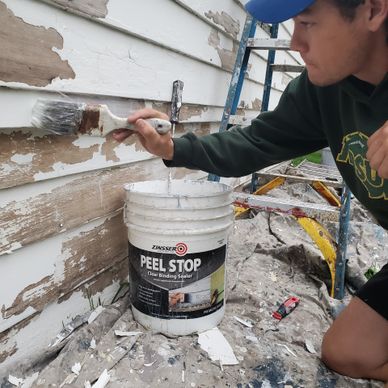 Student painter using Peel Stop primer, priming a house for painting
