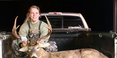 Our current employee, Kaitlen, holding up the huge deer she shot