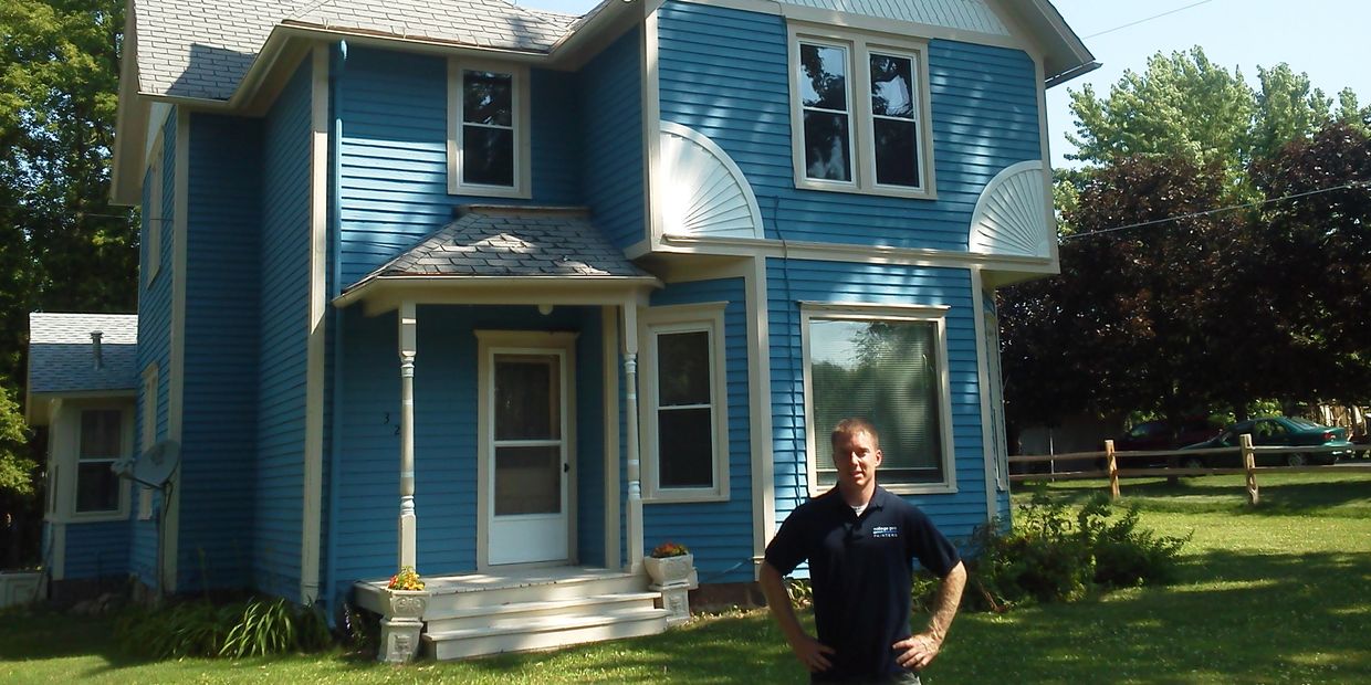 Nic - business owner in front of house he painted