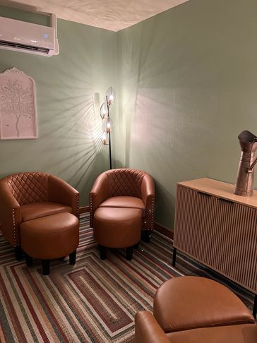 Cozy corner with brown leather chairs and soft lighting.