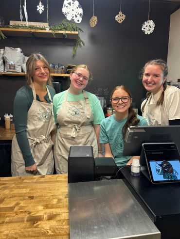 Four smiling employees at Cool Beans Froyo Cafe behind the counter.