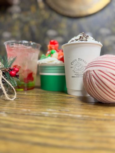 Holiday-themed drinks and desserts on a wooden table with festive decorations.
