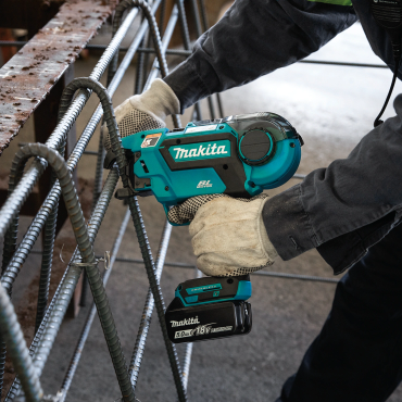 Worker using Makita rebar tying tool on steel reinforcement bars.