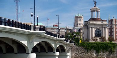 A cityscape featuring a white arched bridge and historic buildings under a blue sky.