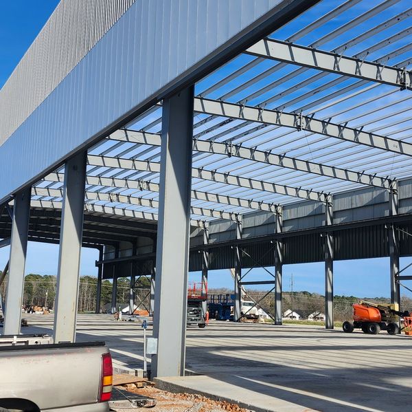 Steel frame structure under construction on a sunny day.