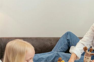 grandmother volunteer and young girl playing with stuffed animals