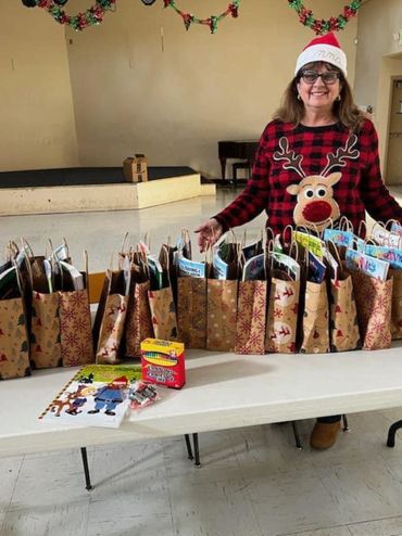 Boardmember Anna Sorci sets up club donated gift bags at Good Shepherd Church for children in need.