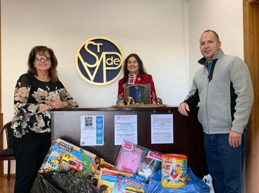 Vince and Anna present gifts to St. Vincent de Paul for children in need.