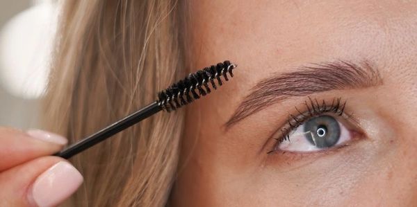 beautician performing precise eyebrow makeup and eyelash enhancement at Florida beauty salon