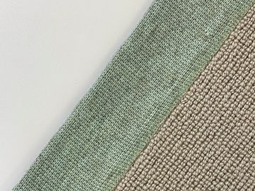 Close-up of two textured fabrics in green and beige colors.