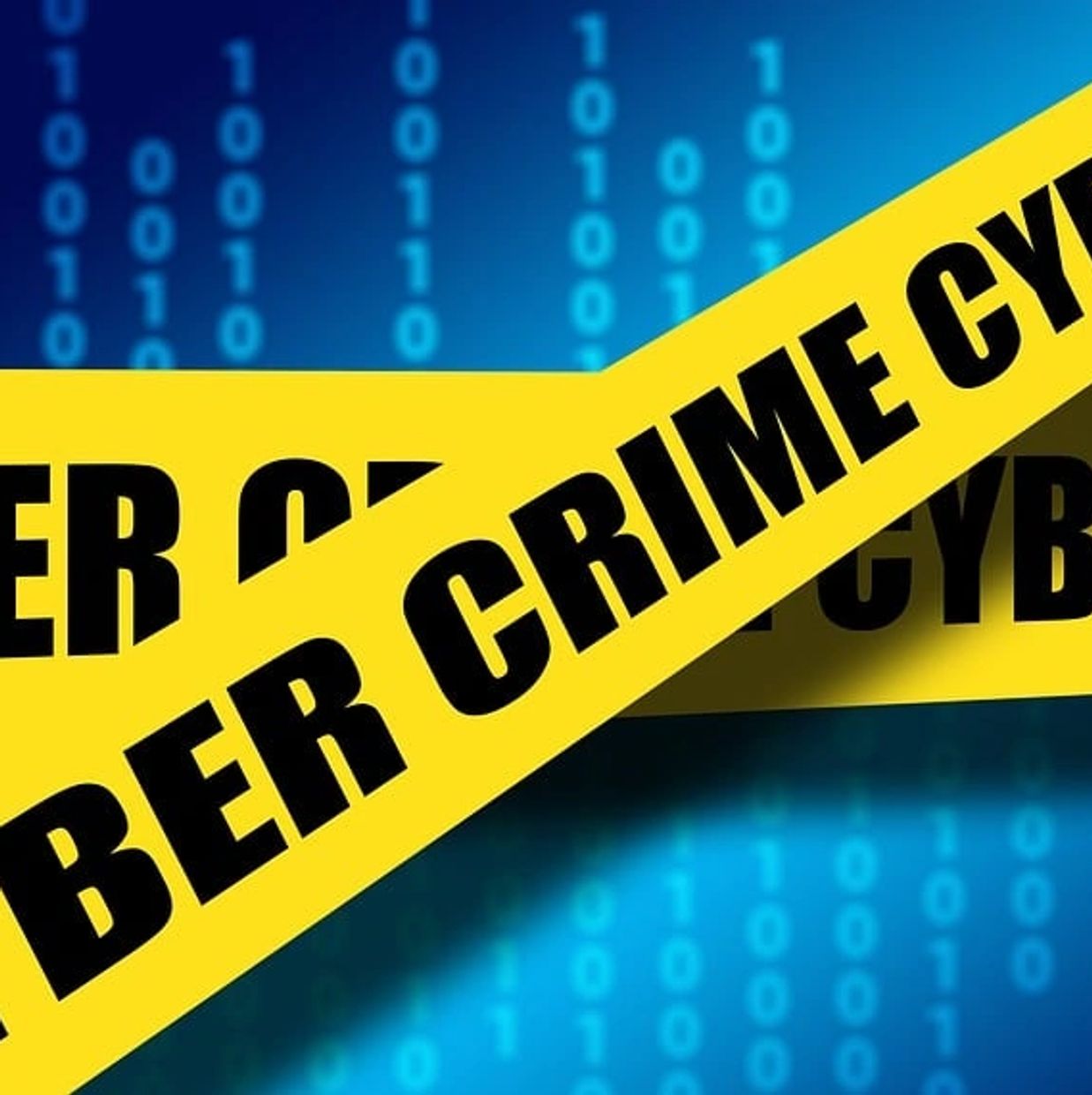 Yellow tape with "CYBER CRIME" text over a blue digital background with binary code.