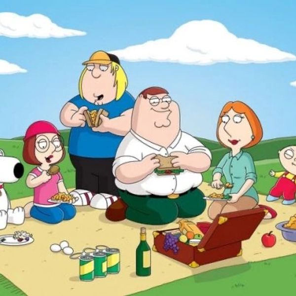 Family picnic scene with animated characters enjoying sandwiches and snacks outdoors.