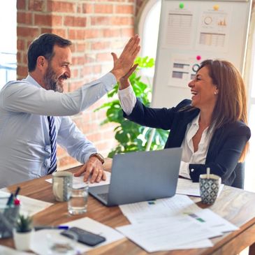 People giving each other a high five after a new successful business strategy implementation.