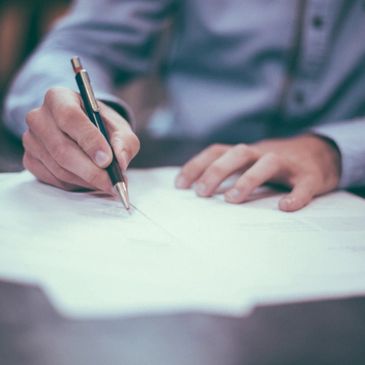 Close up of an accountant working on a clients books writing on a paper
