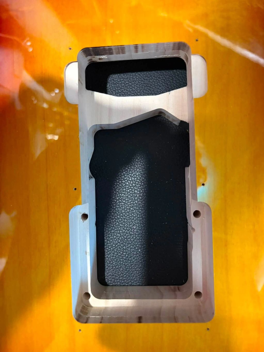 Close-up of a sunburst guitar body pickup cavity.