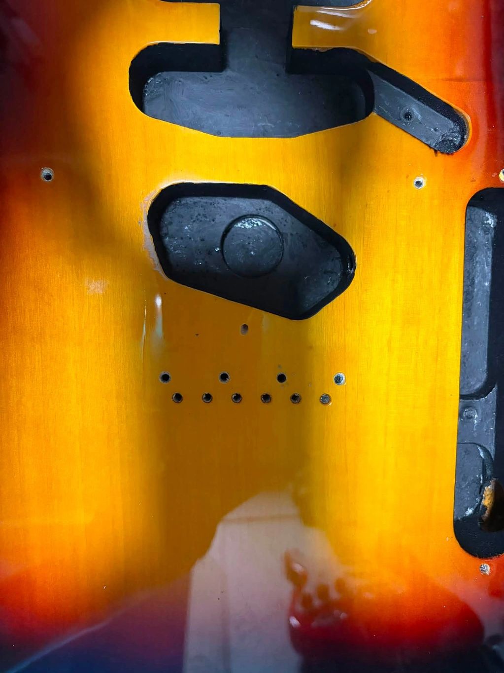 Empty guitar body with cavities for pickups and electronics.