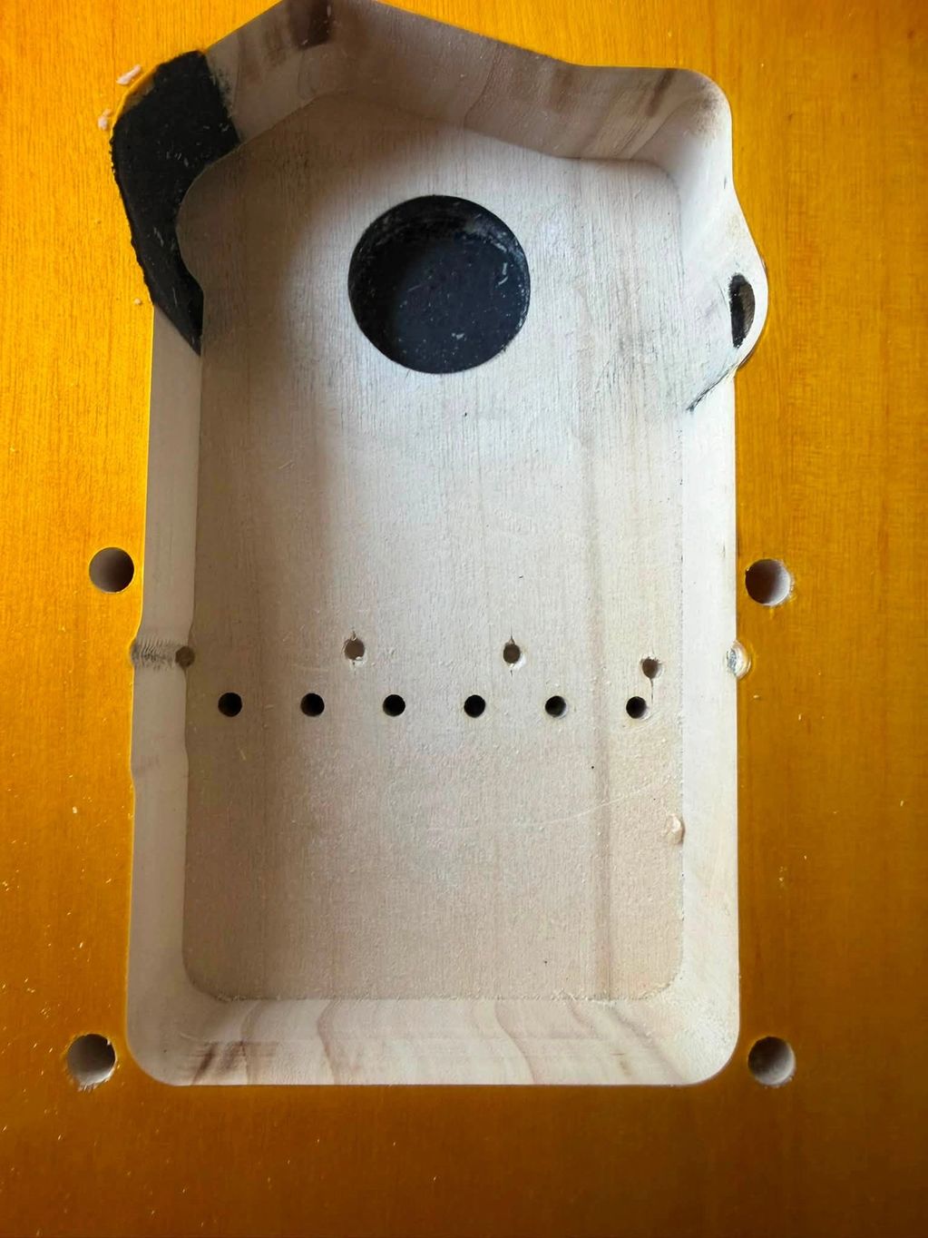 Wooden cavity in a guitar body for electronics.